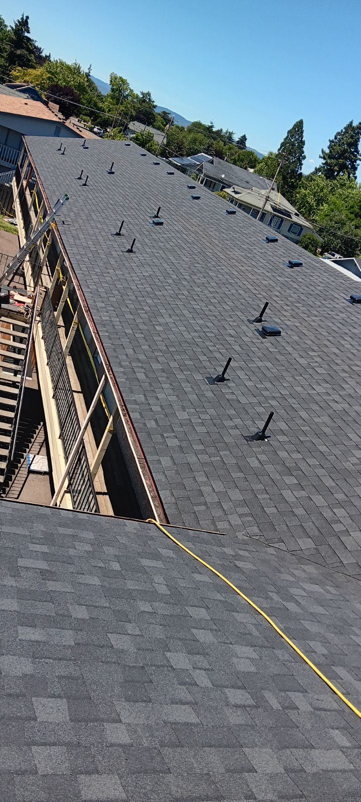 Apartment complex roof mid-installation with safety railing along the edge