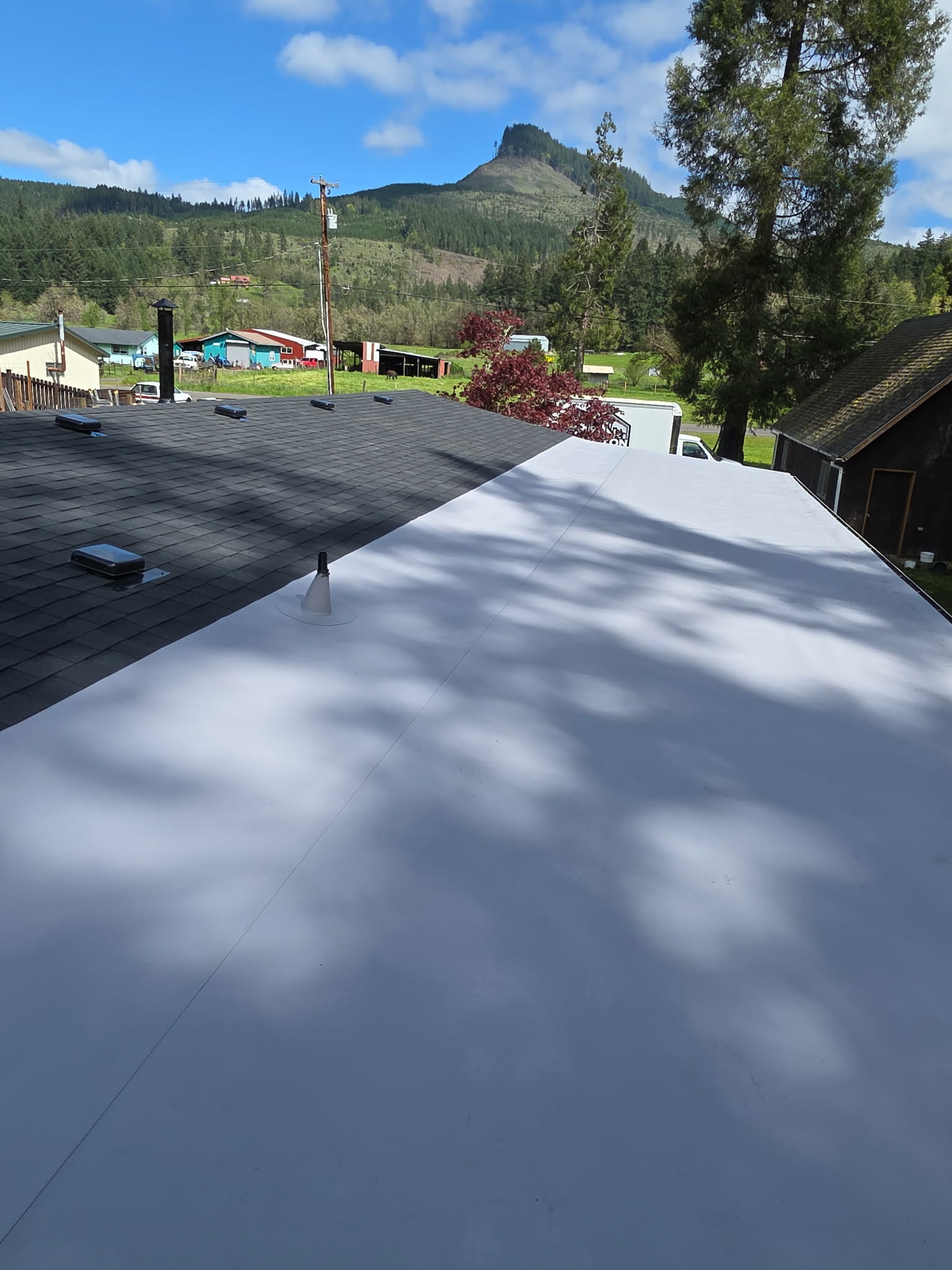 TPO low-slope membrane roof next to a shingled section
