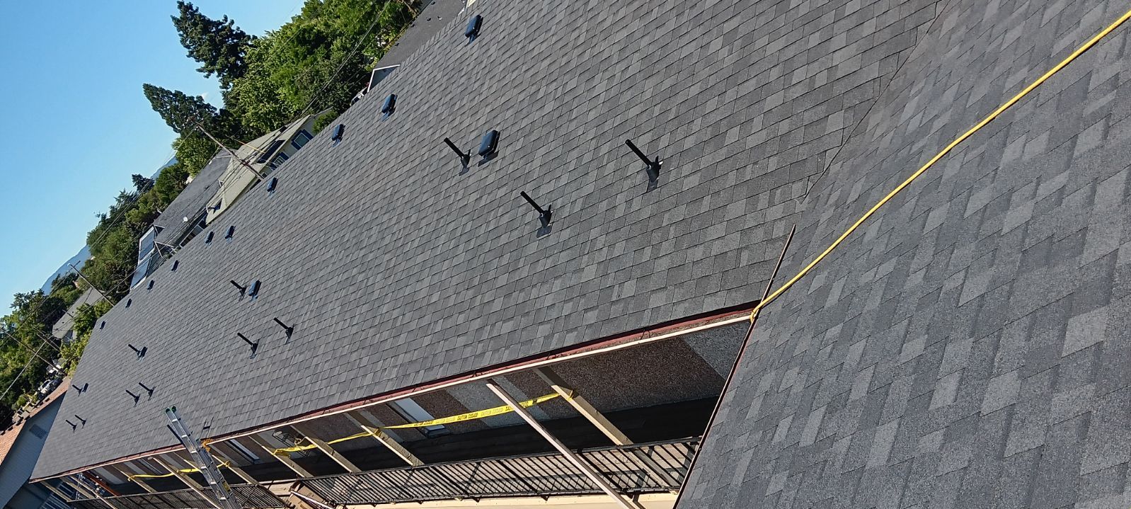 Commercial multi-unit roof with vent stacks and safety line